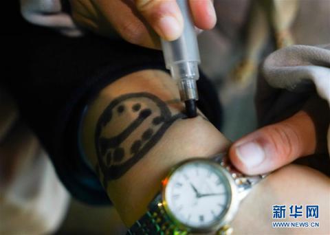 朵朵在站台上将母亲手腕上稍有模糊的“手表”描绘清晰。新华社记者胡晨欢摄