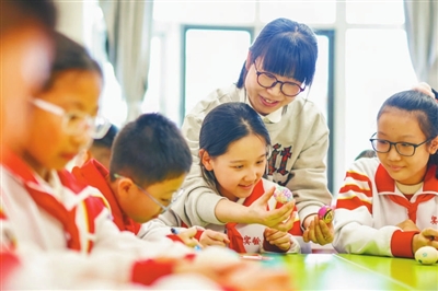 右图为2025年3月20日,天津市滨海新区塘沽实验小学的教师和学生在一起绘彩蛋。新华社发