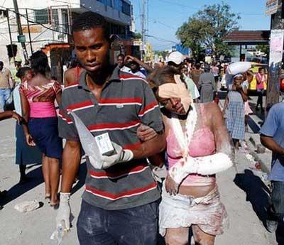 An injured woman is helped after being rescued in Port-au-Prince, Haiti.(AFP/Thony Belizaire)