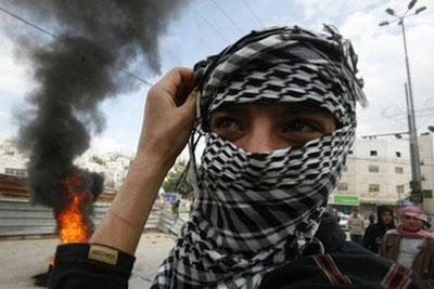 A&nbsp;masked&nbsp;Palestinian&nbsp;demonstrator&nbsp;stands&nbsp;near&nbsp;burning&nbsp;tires&nbsp;during&nbsp;clashes&nbsp;with&nbsp;Israeli&nbsp;forces&nbsp;in&nbsp;the&nbsp;West&nbsp;Bank&nbsp;city&nbsp;of&nbsp;Hebron.&nbsp;(AFP/Hazem&nbsp;Bader)