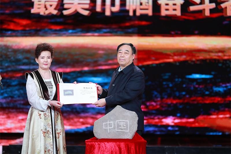 馆藏仪式：中国国家博物馆党委书记、副馆长单威（右一）与新疆妇联代表古丽夏提（左一）交接中国石与收藏证书