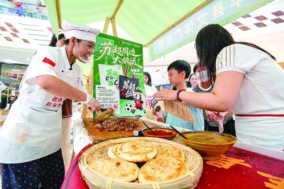 消费者在江苏泰州市海陵区万达广场“跟着苏超游徐州”徐州文旅（泰州）推介会上品尝食品。新华社发