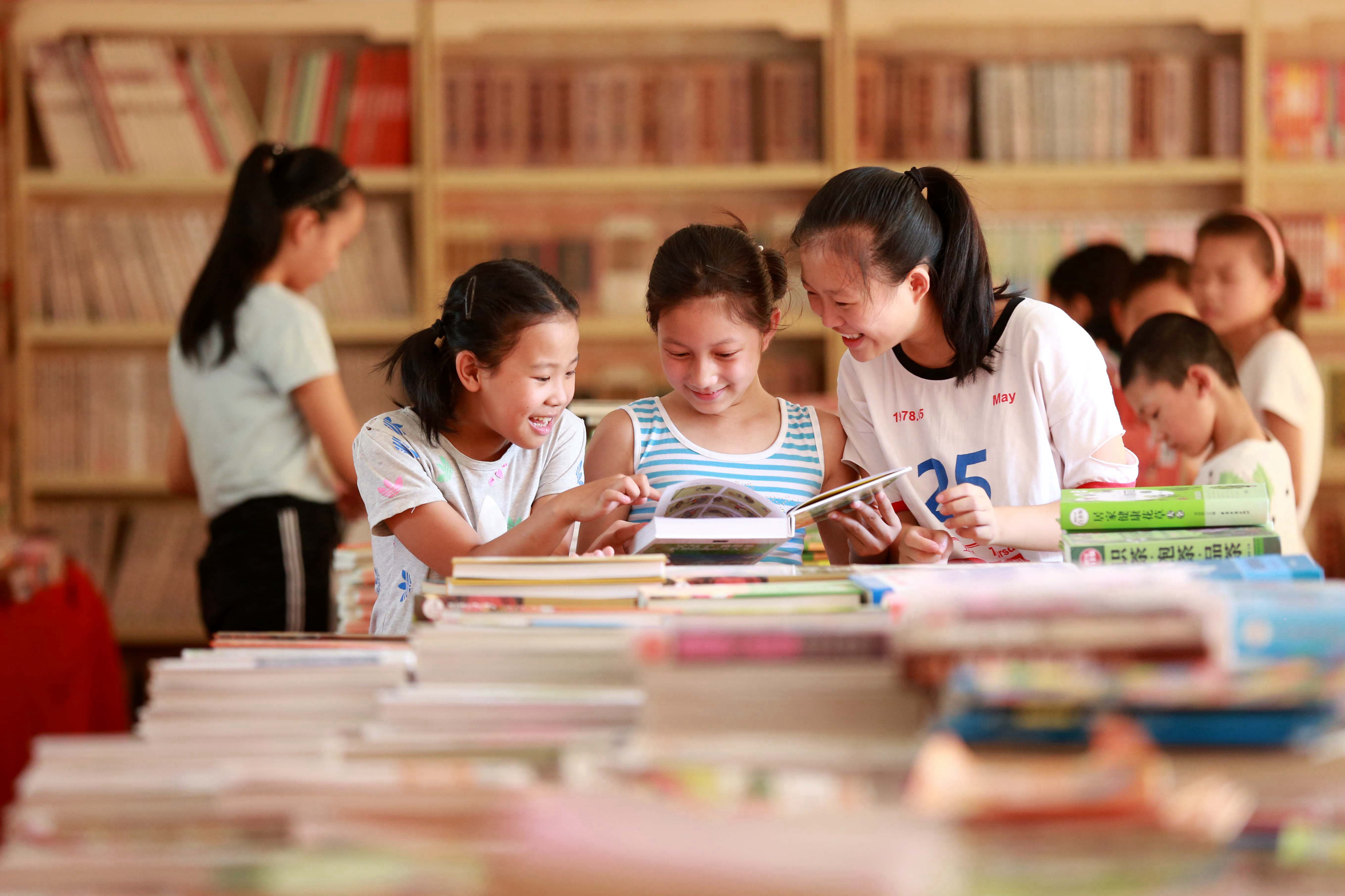 《悦读》 峡江县：几名小孩正在&ldquo;倡导全民阅读 建设书香玉峡&rdquo;图书巡展上看书。曾双全 摄 