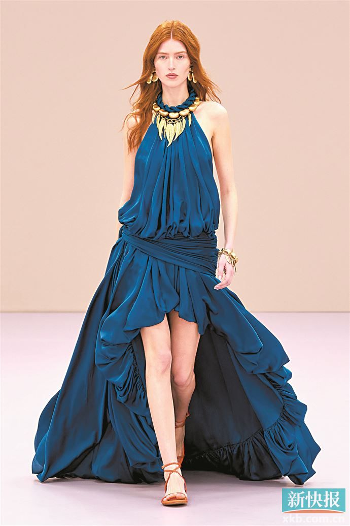 大量感后裙摆剪裁设计对比出纤细腿部线条，提升简洁裙装的华丽重工感。